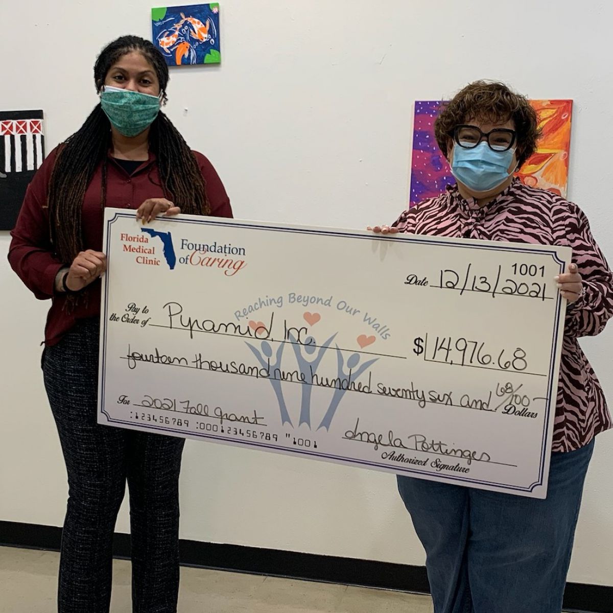 two women holding a big check