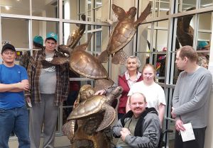 a group of people with a sea turtle statue