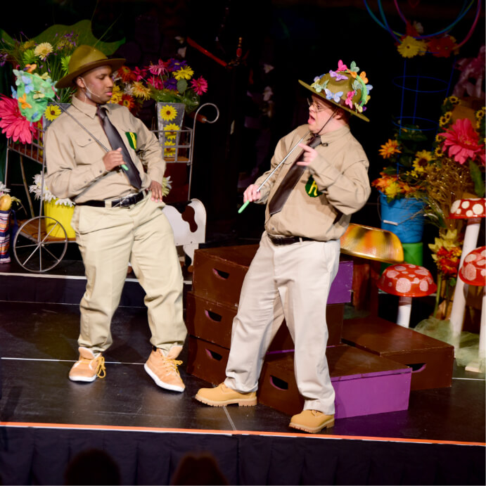 two males in ranger costumes with flowers in their hat